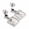 A pair of silver drop earrings featuring square open-frame dangles with white freshwater pearls and small round brown gemstone accents, shown on a white background.