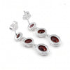 A pair of silver drop earrings featuring three oval-cut dark red gemstones in each earring, set in a wavy, layered silver bezel design with secure post-back closures, shown on a plain white background.