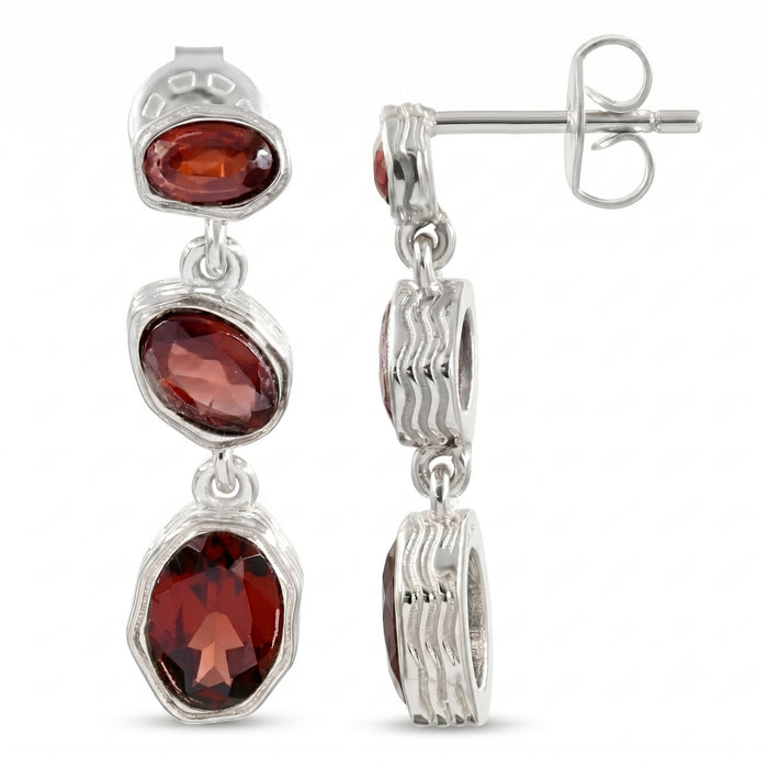 A pair of sterling silver drop earrings featuring three oval-cut garnet gemstones, shown with one earring facing forward and the other showing the side profile and butterfly back.