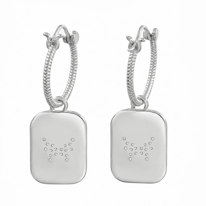 A pair of silver hoop earrings with rectangular drop pendants, featuring a small constellation design of dots on each pendant, set against a plain white background.