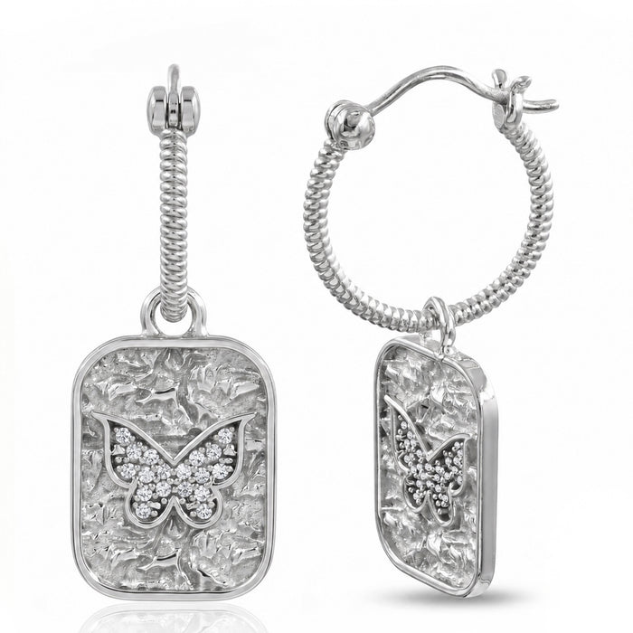 A pair of silver drop earrings featuring textured rectangular pendants with a butterfly motif paved with small clear stones, shown on a white background.