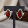 Red onyx J-Hoop earrings with Swarovski crystals in silver plated finish, displayed on a black T-shape stand containing both earrings.