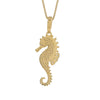 A gold seahorse pendant necklace on a matching chain, featuring a textured, pave-set design on a solid white background.