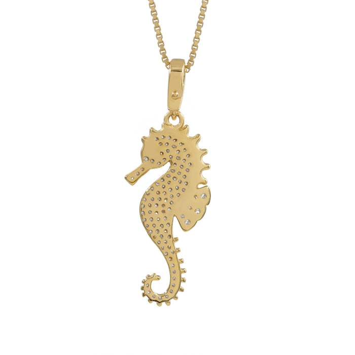 A gold seahorse pendant necklace on a matching chain, featuring a textured, pave-set design on a solid white background.