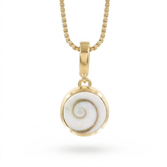 A gold necklace with a round bezel pendant featuring a Shiva Eye shell inlay, suspended from a gold box chain against a white background.