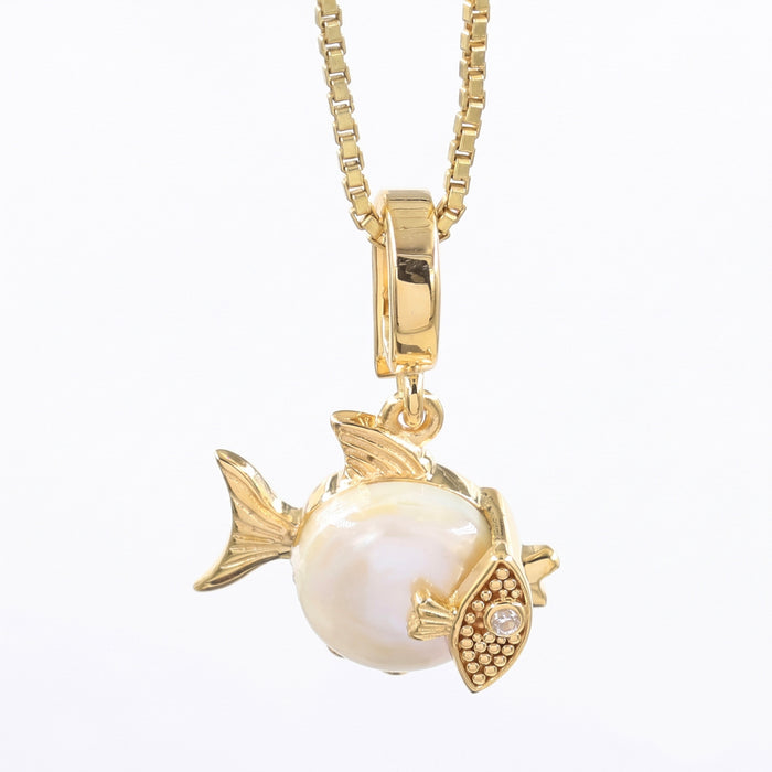 A gold fish pendant necklace featuring a large white pearl belly and a gold eye with tiny clear stones, suspended from a gold box chain on a white background.