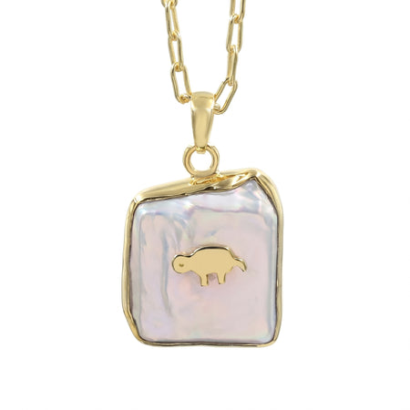 A gold chain necklace with a free size and fancy shape pendant featuring a white iridescent -biwa pearl background and a small gold animal in the center, shown on a plain white background.