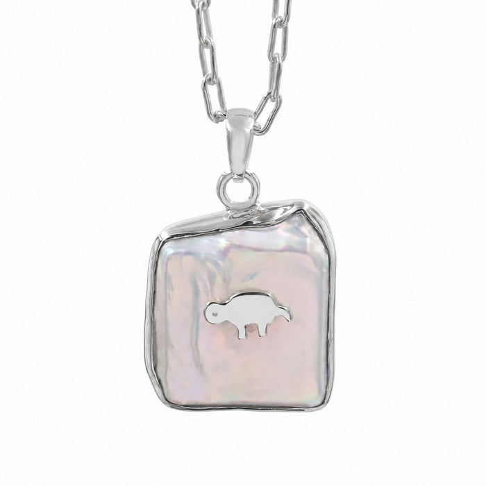 A silver chain necklace with a free size and fancy shape pendant featuring a white iridescent -biwa pearl background and a small gold animal in the center, shown on a plain white background.
