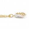 Side view of a gold paperclip chain necklace with a single free-size baroque freshwater pearl pendant featuring metal stud accents