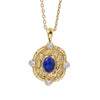 A gold pendant necklace featuring a textured circular medallion with a central deep blue lapis lazuli stone and four small clear round-cut accent stones, suspended from a gold chain against a plain white background.