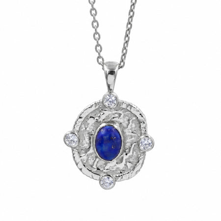 A silver pendant necklace featuring a textured round silver frame with four clear round-cut stones and a central oval blue lapis lazuli stone, suspended from a silver chain on a white background.