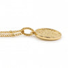 A 18K gold plated coin pendant necklace featuring an embossed circular design, suspended from a gold chain against a plain white background.