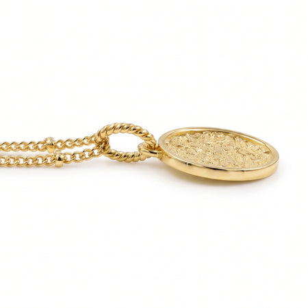 A 18K gold plated coin pendant necklace featuring an embossed circular design, suspended from a gold chain against a plain white background.