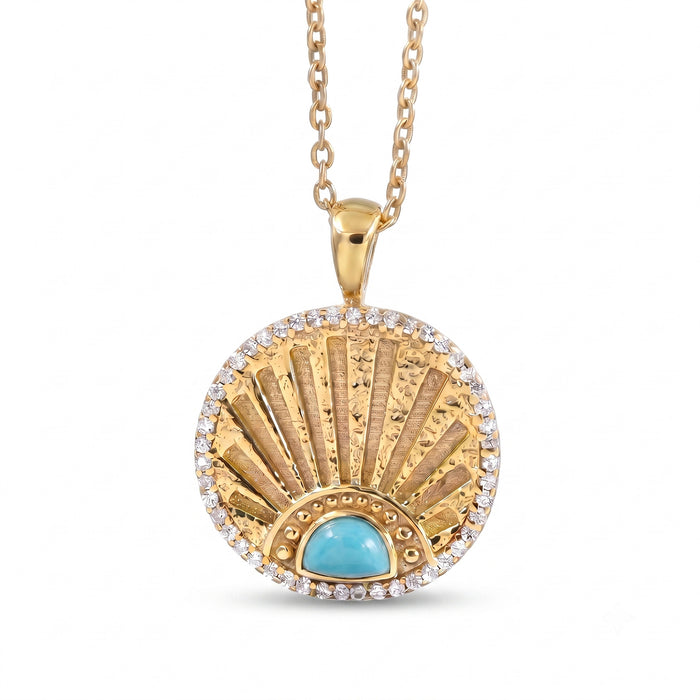 A gold pendant necklace featuring a circular fanburst design with a central turquoise stone and a border of small clear stones, shown on a white background.