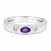 A silver band ring featuring a textured finish, a central oval purple amethyst stone, and two small round-cut clear stones on either side.
