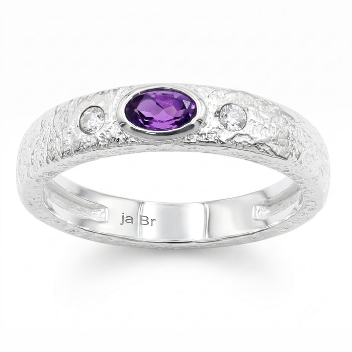 A textured sterling silver ring featuring a central oval-cut purple amethyst gemstone and two small round clear accent stones on a white background.