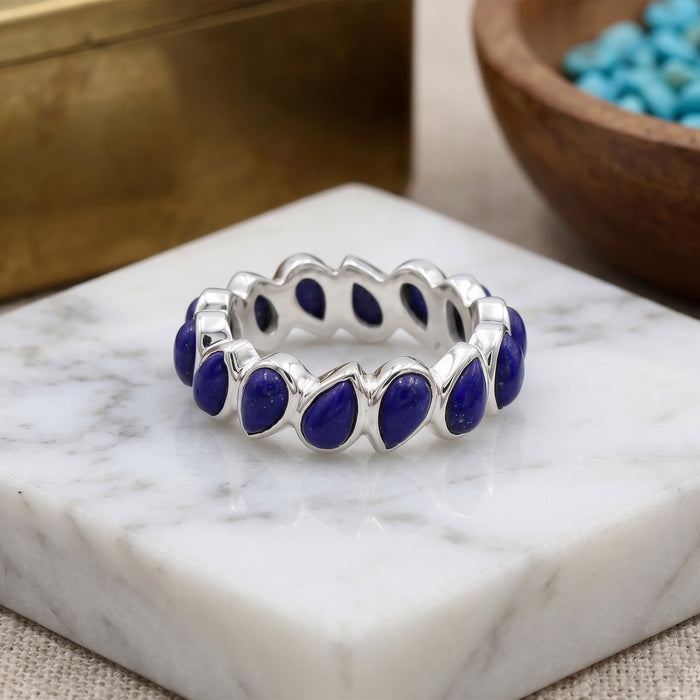 Close-up view of lapis lazuli pear-cut eternity ring showing prong settings and natural pyrite inclusions