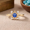 
Natural tanzanite and Swarovski crystal bezel ring in 18K gold plated and silver plated finishes with round gemstones.