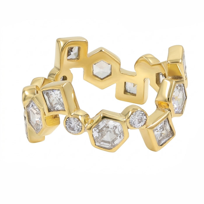 A gold ring featuring a series of hexagonal, round and square bezel-set clear gemstones, displayed on a clean white background.