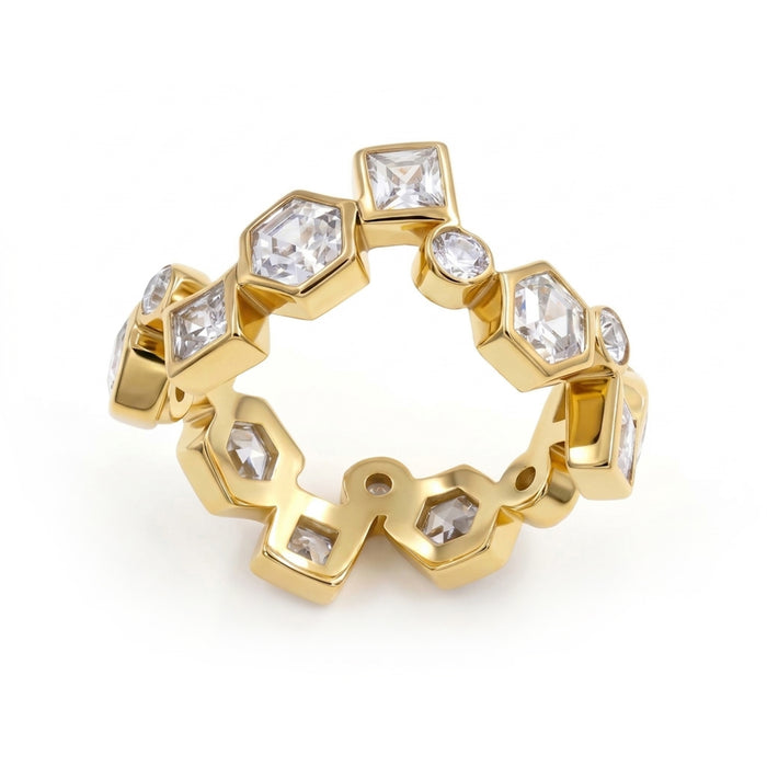 A gold ring featuring a series of hexagonal, round and square bezel-set clear gemstones, displayed on a clean white background.