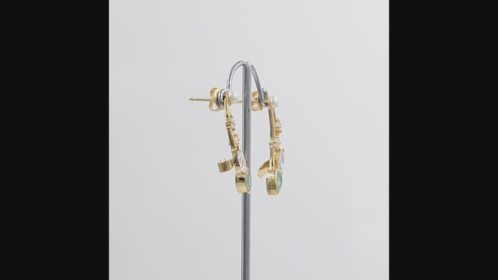 360 degree view of Gold-plated ear climber earrings featuring a marquise-cut Swarovski crystal stone, a pear-shaped light green aquamarine stone, a round pearl, and small clear accent stones, views on a white background.