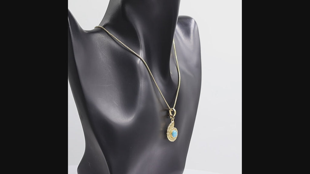 360 degree view of a gold pendant necklace featuring a Nautilus shell design with a round turquoise blue stone in the center, suspended from a gold box chain against a white background.