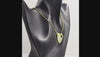 A gold heart-shaped pendant necklace with a textured finish, featuring a row of clear swarovski crystal round-cut stones on the left side and a toggle clasp at the top right, suspended from a gold chain against a white background.