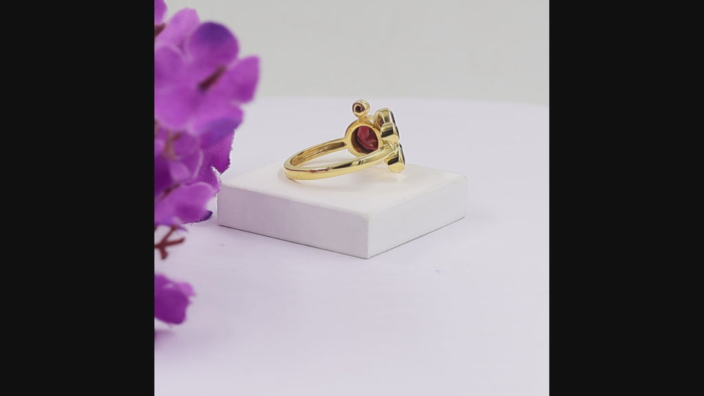 Natural garnet floral bypass ring with pear-cut garnet gemstones and Swarovski crystal accents in 18K gold & silver plated finish on a white background.