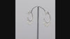 A pair of silver hoop earrings with dangling pearl beads and small gold beads, shown on a plain white background.
