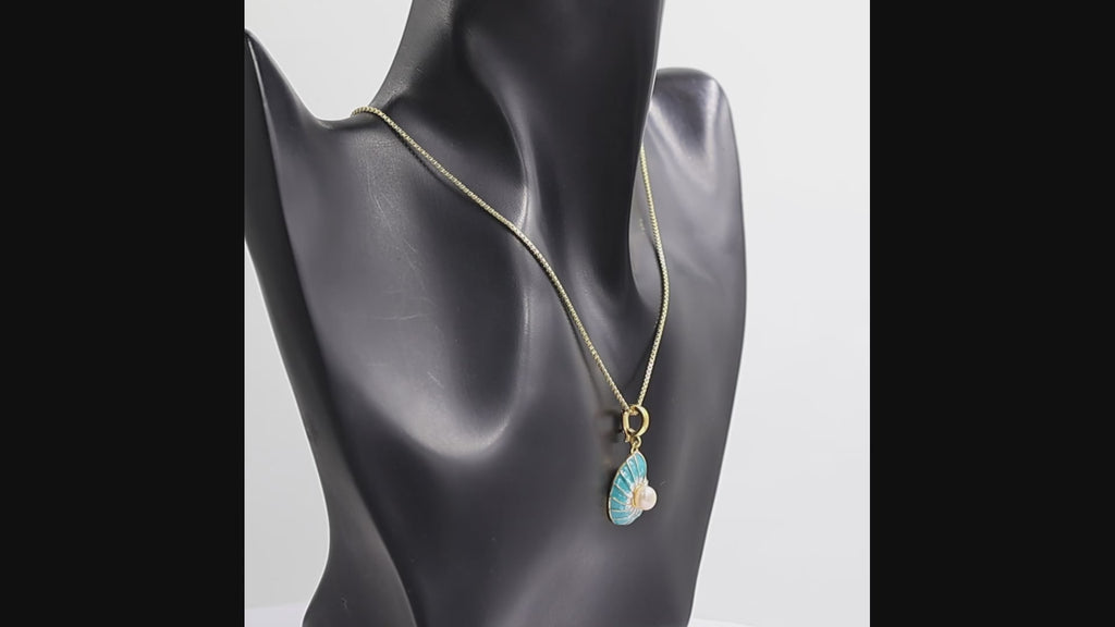 360 degree view of a  gold pendant necklace featuring a nautilus shell design with a central white pearl, and a gold box chain on a white background.