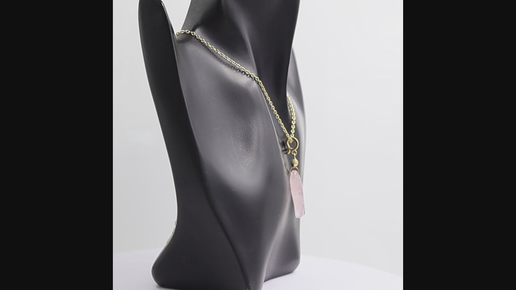 360 degree view of a gold chain necklace featuring a polished pink rose quartz fish pendant with a textured gold bead accent and gold bail, shown against a plain white background.