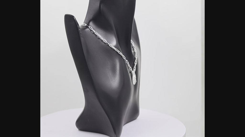 360 degree view of a silver pendant necklace featuring a textured with a dragonfly and a small black-onyx gemstone, suspended from a silver paperclip chain against a white background.