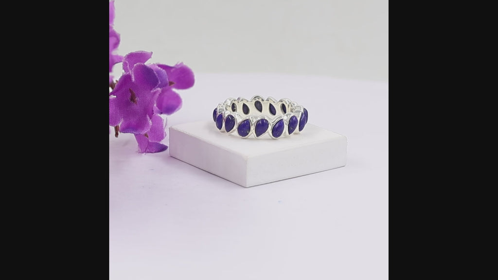 Close-up view of lapis lazuli pear-cut eternity ring showing prong settings and natural pyrite inclusions